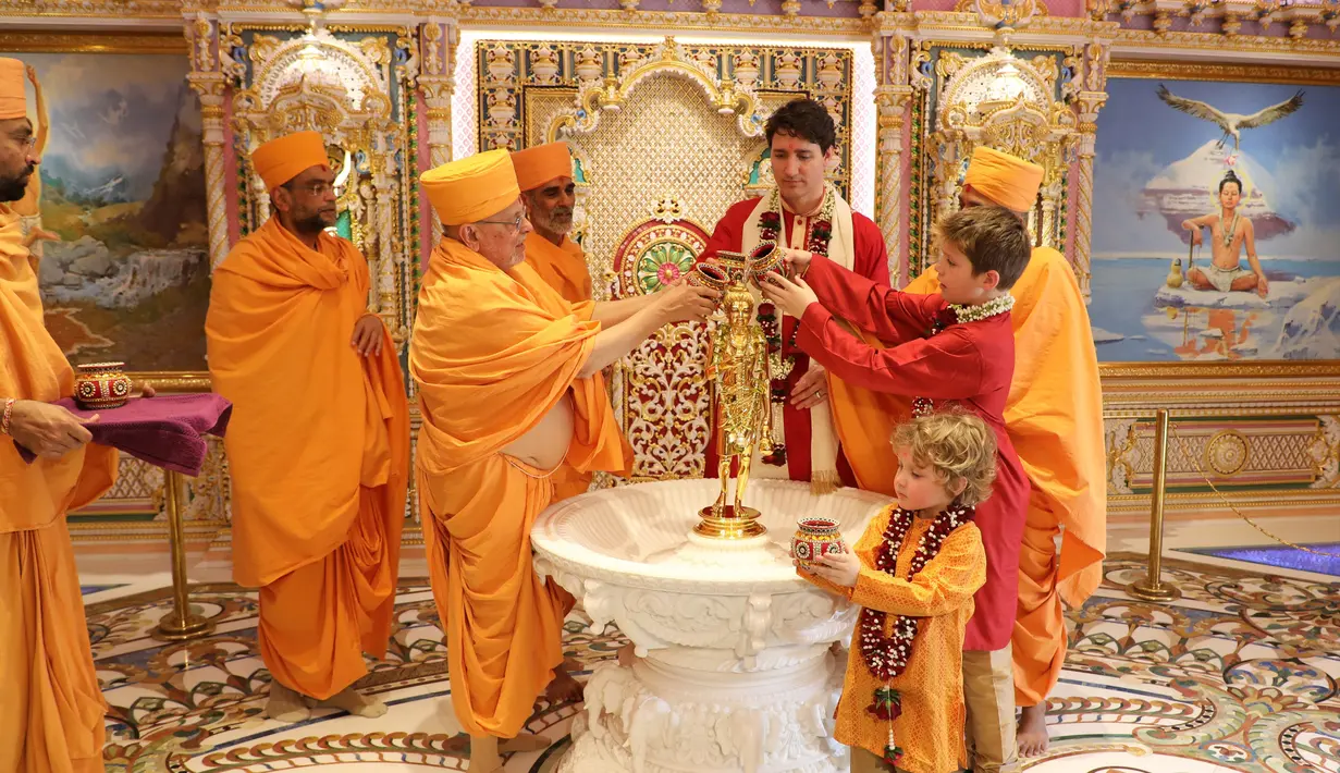 Perdana Menteri Kanada Justin Trudeau bersama dua anaknya mengikuti ritual di Kuil Swaminarayan Akshardham, India (19/2). (AFP Photo/Swaminarayan Akshardham Temple)