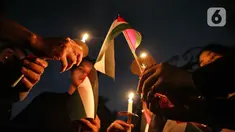 Sejumlah elemen masyarakat menyalakan lilin saat mengikuti Aksi Damai Bela Palestina di Kedutaan Besar Palestina, Jakarta, Kamis (2/11/2023). (Liputan6.com/Faizal Fanani)