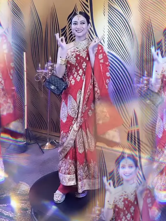 Rini Yulianti tampil dengan busana khas perempuan india warna merah keemasan. Lengkap dengan aksesori kepala dan perhiasannya. [@riniyulianti]