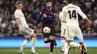 Aksi Gerard Pique melewati Toni Kross pada laga semfinal Copa Del Rey yang berlangsung di stadion Santiago Bernabeu, Madrid, Kamis (28/2). Barcelona menang 3-0 atas Real Madrid. (AFP/Oscar Del Pozo)