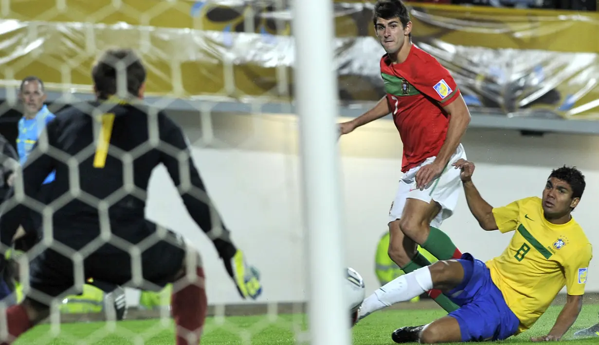 Pemain Timnas Brasil U-20, Casemiro (kanan) berusaha menghadang tendangan dari pemain Portugal U-20, Nelson Oliveira pada pertandingan final Piala Dunia U-20 2011 yang berlangsung di El Campin, Bogota, Kolombia, Sabtu (20/8/2011). (AFP/Aizar Raldes)