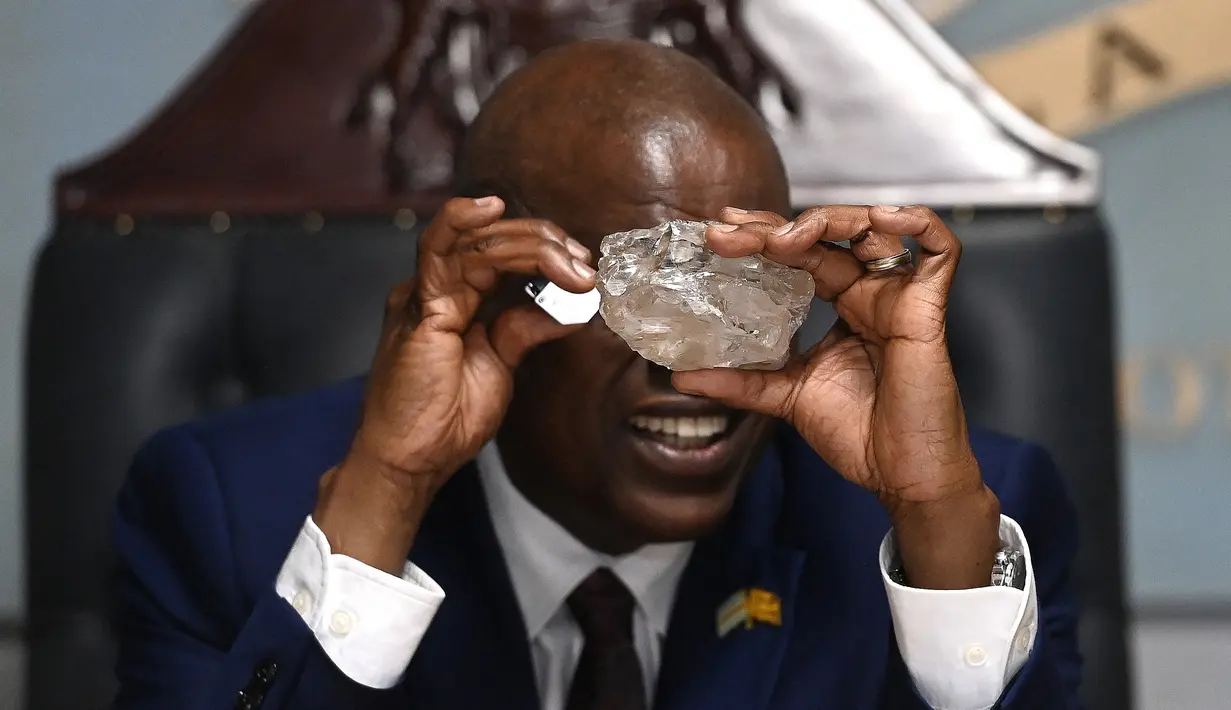 Presiden Botswana Mokgweetsi Masisi melihat berlian terbesar yang ditemukan di Botswana, di kantornya, Gaborone pada 22 Agustus 2024. (Monirul BHUIYAN / AFP)