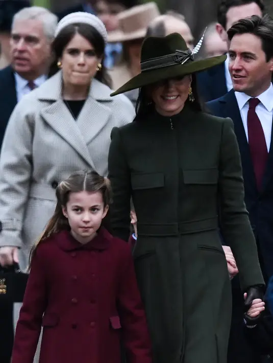 Kate Middleton, Princess of Wales dari Inggris bersama Putri Charlotte tiba untuk kebaktian Natal di Sandringham, Norfolk, Inggris pada 25 Desember 2022. Kate memasangkan mantel tersebut dengan sepatu bot hitam berbahan suede Gianvitto Rossi, lengkap dengan hak chunky. (AFP/Daniel Leal)