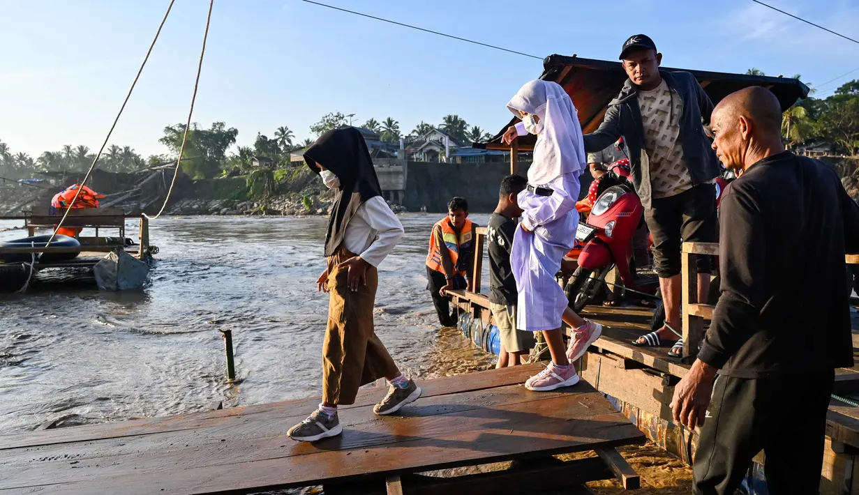 Ketetapan tersebut tertuang dalam Surat Edaran bernomor 400.3/2026 yang ditandatangani Kepala Dinas Pendidikan dan Kebudayaan Kabupaten Bireuen, dan ditujukan kepada seluruh Kepala UPTD PAUD, SD, dan SMP. Tampak dalam foto, sejumlah siswa menaiki perahu darurat untuk menyeberangi Sungai Peusangan pasca banjir bandang yang menghancurkan desa-desa di sekitarnya di kabupaten Bireuen, provinsi Aceh, Indonesia pada Senin 5 Januari 2026. (CHAIDEER MAHYUDDIN/AFP)