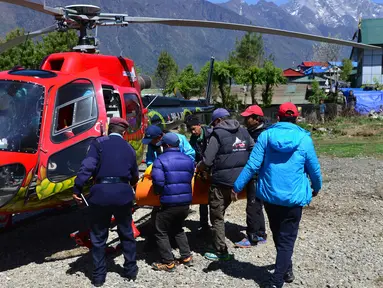 Petugas memasukkan jasad pendaki gunung tertua di dunia asal Nepal, Min Bahadur Sherchan, yang tewas di puncak Pegunungan Everest ke dalam helikopter, Minggu (7/5). Kakek 85 tahun itu ditemukan meninggal di basecamp-nya pada Sabtu. (PRAKASH MATHEMA/AFP)