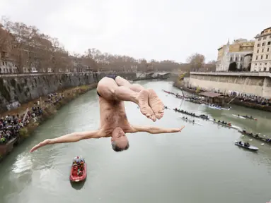 Marco Fois menyelam ke dalam Sungai Tiber untuk merayakan tahun baru 2024 di Roma, Italia, Senin (1/1/2024). (AP Photo/Domenico Stinellis)