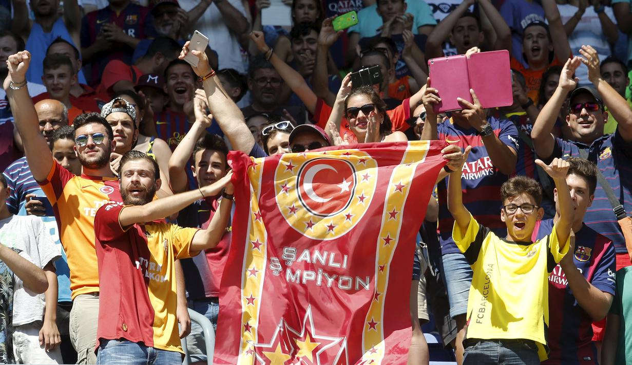 Aksi suporter saat Arda Turan diperkenalkan secara resmi kepada publik dalam suatu acara di Camp Nou, markas Barcelona. Jumat (10/7/2015). (Reuters/Gustau Nacarino)