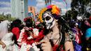 Seorang wanita menghias wajahnya saat parade "Day of the Dead" di Mexico City, Meksiko, Sabtu, (29/10). Festival Kematian bertujuan untuk mengenang dan menghormati orang-orang yang telah meninggal. (REUTERS / Carlos Jasso)