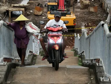 Pengendara motor melintas di samping pejalan kaki menaiki Jembatan Penyeberangan Orang kawasan Cikunir, Bekasi Barat, Senin (12/3). JPO yang diperuntukkan bagi pejalan kaki ini justru digunakan pemotor mencari jalan pintas. (Liputan6.com/Arya Manggala)