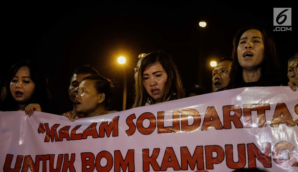 assa dari Solidaritas Merah Putih menggelar aksi lilin dan tabur bunga di lokasi bom Terminal Kampung Melayu, Jakarta, Kamis (25/5). Aksi tersebut sebagai bentuk malam solidaritas duka untuk bom Kampung Melayu.(Liputan6.com/Faizal Fanani)