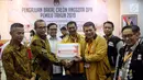 Sekjen Partai Hanura Harry Lontung Siregar (dua kanan) berjabat tangan dengan Komisioner KPU Hasyim Asy'ari (dua kiri) saat menyerahkan berkas pendaftaran bakal calon legislatif di KPU, Jakarta, Selasa (17/7). (Liputan6.com/JohanTallo)
