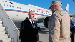 Presiden Rusia, Vladimir Putin tiba di pangkalan udara Hemeimeem di Suriah (11/12). Putin berhenti di pangkalan udara Hemeimeem di Provinsi pesisir Latakia di Suriah saat perjalanan menuju Mesir. (Mikhail Klimentyev, Sputnik, Kremlin Pool Photo via AP)
