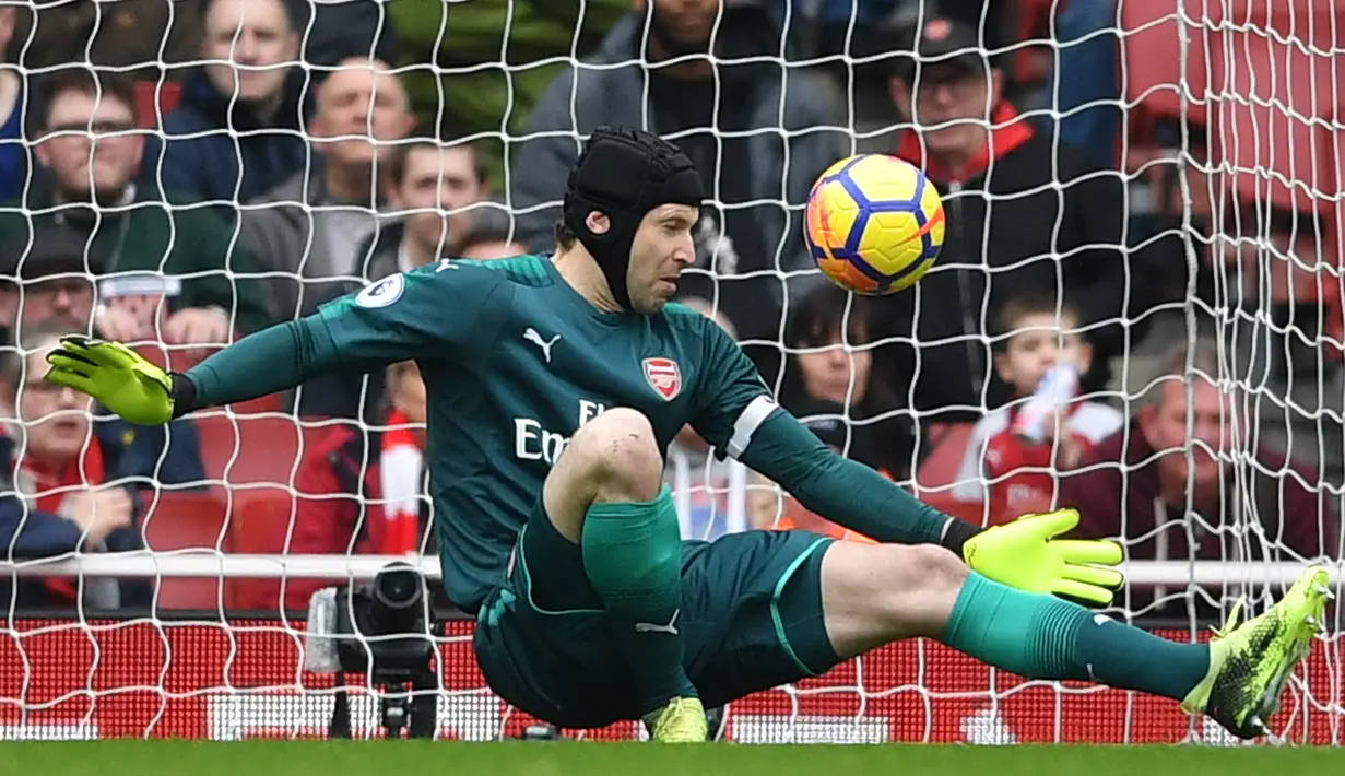 Kiper Arsenal Arsenal, Petr Cech berhasil mengagalkan tendangan pemain  Watford pada lanjutan pertandingan Liga Inggris di Emirates Stadium, Minggu (11/3). Arsenal sukses mengandaskan Watford dengan skor menyakinkan 3-0. (Ben STANSALL / AFP)