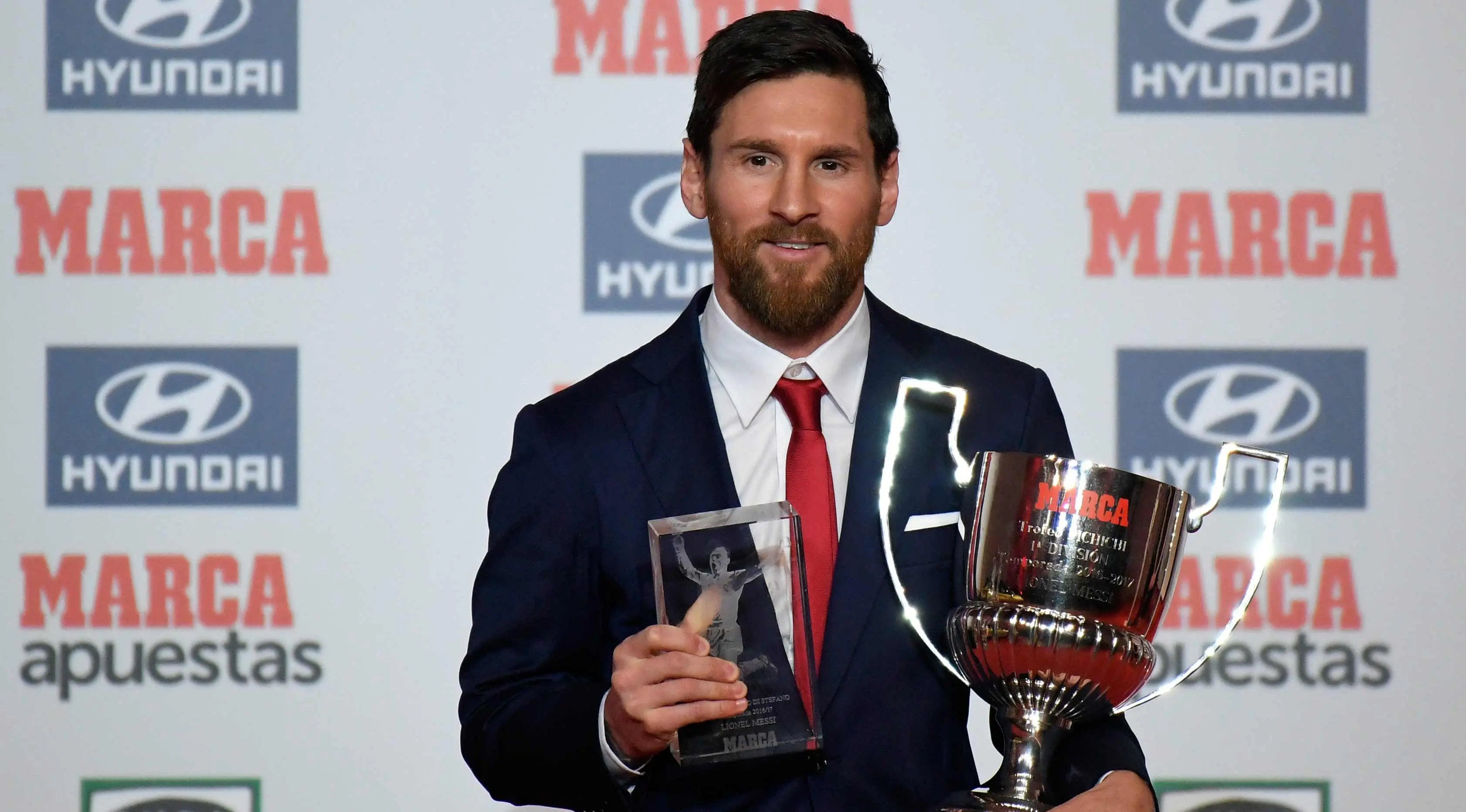 Penyerang Barcelona, Lionel Messi berpose setelah menerima penghargaan Pichichi Trophy untuk pencetak gol terbanyak 2016-17 di liga Spanyol dan Alfredo Di Stefano Trophy di Barcelona (18/12). (AFP Photo/Lluis Gene)