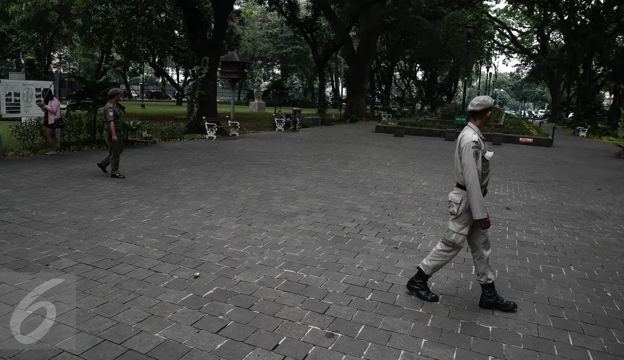 Petugas Satpol PP disebar untuk melakukan penjagaan di sekitar Taman Suropati, Jakarta, Selasa (14/6). Kini, Taman Suropati disterilkan dari PKL dan bersih dari parkir liar yang biasa terlihat di bahu jalan tepian taman. (Liputan6.com/Faizal Fanani)
