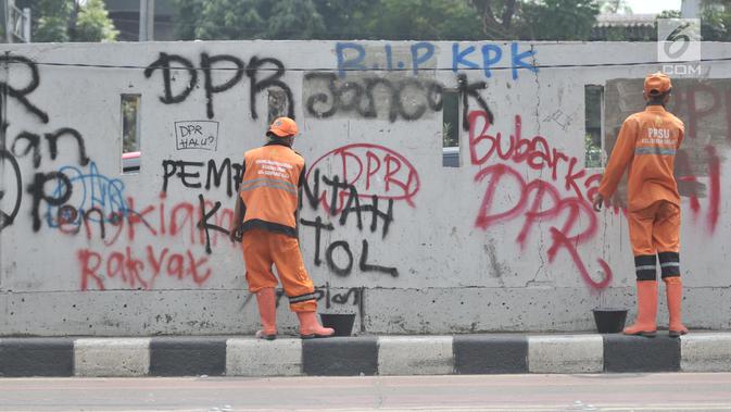 Petugas PPSU mengecat coretan yang mengotori tembok di kawasan Gedung DPR, Jakarta, Rabu (25/9/2019). Demonstrasi mahasiswa yang berujung ricuh yang berujung kerusuhan tersebut menyebabkan fasilitas umum rusak dan penuh coretan yang dibuat oleh pendemo. (merdeka.com/Iqbal S Nugroho)