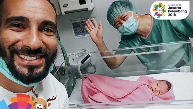 Gelandang Persela, Diego Assis, berpose bersama putri mungilnya yang lahir saat HUT ke-73 RI, Jumat (17/8/2018), di Surabaya. (Bola.com/Dok. Persela)