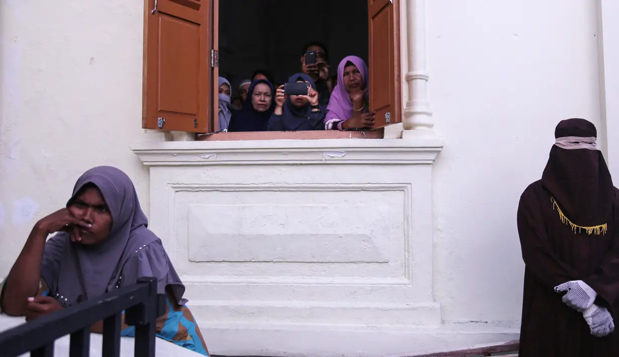Petugas syariah bersiap menghukum cambuk terpidana kasus lainnya di depan Masjid Baiturrahim, Banda Aceh (13/7). (AP Photo/Heri Juanda)