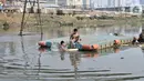 Anak-anak berenang di Kanal Banjir Barat, Jakarta, Minggu (3/11/2019). Banyaknya sampah yang menggenang tidak menghentikan keseruan anak-anak berenang di Kanal Banjir Barat. (merdeka.com/Iqbal Nugroho)