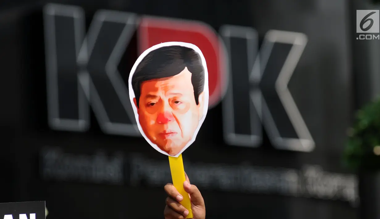 Aktivis Koalisi Masyarakat Sipil Anti Korupsi mengangkat topeng saat aksi teatrikal di depan Gedung KPK, Jakarta, Kamis (14/9). Mereka menuntut KPK menahan tersangka kasus dugaan korupsi KTP elektronik, Setya Novanto. (Liputan6.com/Helmi Fithriansyah)