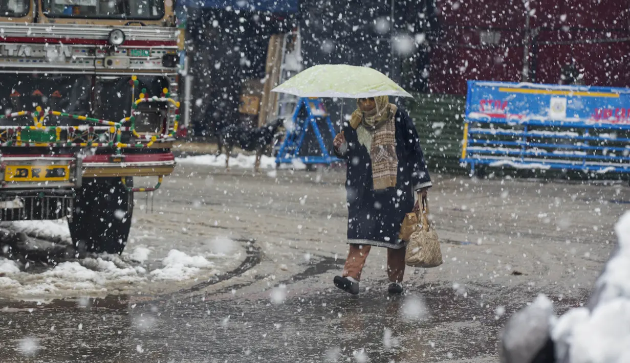 Seorang wanita Kashmir berjalan saat salju turun di Srinagar, Kashmir yang dikuasai India (15/1/2020). Selama dua hari terakhir wilayah Himalaya telah menyaksikan hujan salju lebat yang mengakibatkan serangkaian longsoran dan tanah longsor. (AP Photo/Dar Yasin)