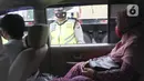 Polisi melakukan pemeriksaan bagian belakang sebuah mobil saat penyekatan larangan mudik lebaran di gerbang tol Cikupa, Kabupaten Tangerang, Banten, Kamis (6/5/2021). Penyekatan dilakukan seiring telah diberlakukan larangan mudik Lebaran mulai dari 6 hingga 17 Mei 2021.  (Liputan6.com/Angga Yuniar)