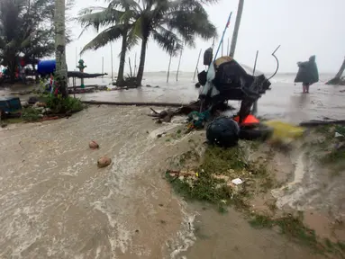 Banjir meluap di atas jalan pantai ketika Badai Tropis Pabuk mendekat di Pak Phanang, di Nakhon Si Thammarat, Thailand Selatan (4/1). Hujan, angin dan gelombang air laut akan melanda Thailand selatan akibat badai tropis Pabuk. (AP Photo/Sumeth Panpetch)