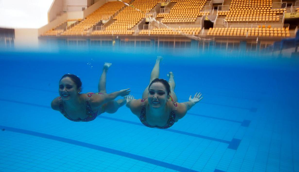 Atlet renang indah Brasil, Maria Eduarda Miccuci (kanan) dan Luisa Borges beraksi dalam sesi foto jelang Olimpiade Rio 2016 di Rio Olympic Park, Rio de Janeiro, Brasil, (Reuters/Pilar Olivares)