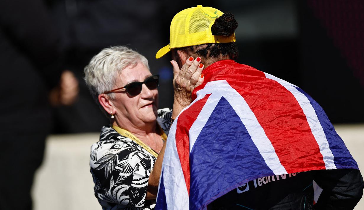 Pembalap Mercedes, Lewis Hamilton merayakan kemenangan bersama ibunya saat menjuarai Formula 1 GP Inggris 2024 yang berlangsung di Sirkuit Silverstone, Inggris, Minggu (08/07/2024). (AFP/Benjamin Cremel)