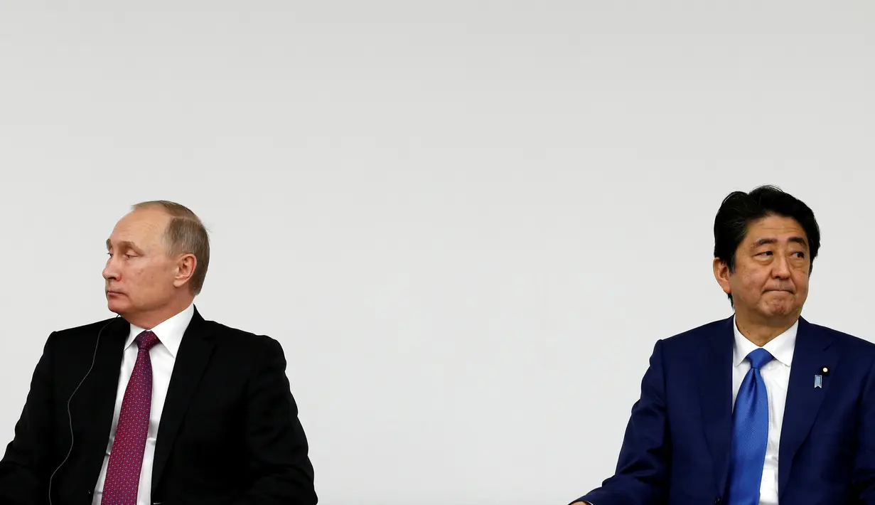 Presiden Rusia Vladimir Putin dan Perdana Menteri Jepang Shinzo Abe menggelar konferensi pers di Tokyo, Jumat (16/12). Pertemuan Putin dan Abe membahas soal wilayah sengketa antara Jepang dan Rusia. (REUTERS/Kim Kyung-Hoon)