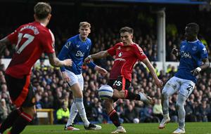 Gelandang Manchester United (MU), Manuel Ugarte, melepaskan tembakan yang berbuah gol kedua timnya kala bertandang ke Goodison Park, markas Everton, pada laga pekan ke-26 Premier League 2024/2025, Sabtu (22/2/2025) malam WIB. MU membawa pulang satu poin setelah bermain imbang 2-2 dengan The Toffees. (Paul ELLIS / AFP)