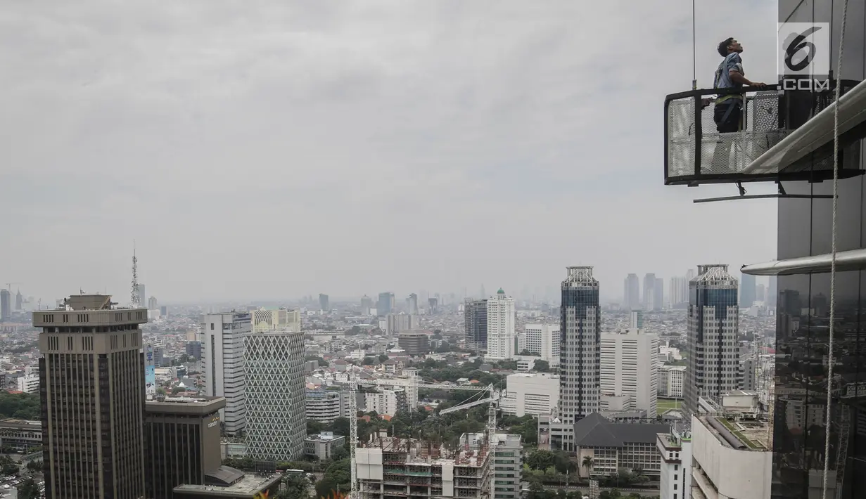 Pekerja tanpa helm keselamatan beraktivitas di gedung bertingkat di Jakarta, Rabu (15/11). Banyak kejadian kecelakaan kerja di ketinggian disebabkan karena minimnya pengetahuan dasar mengenai keselamatan kerja di ketinggian. (Liputan6.com/Faizal Fanani)
