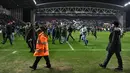 Keributan terjadi setelah Manchester City dikalahkan Wigan 0-1 pada babak kelima Piala FA di Stadion DW, Senin (19/2). Begitu peluit akhir dibunyikan wasit, suporter Manchester City tampak marah. (Oli SCARFF/AFP)