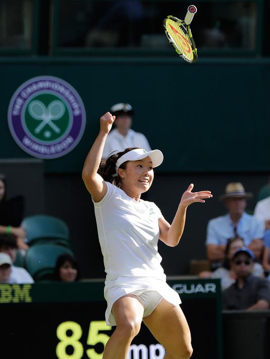 Ekspresi petenis Jepang Kurumi Nara saat raketnya terlepas dari tangan mengembalikan bola pukulan Petenis Rumania Simona Halep saat bertanding pada hari kedua tunggal putri Kejuaraan Tenis Wimbledon di London, (3/7). (AP Photo / Ben Curtis)