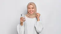 Ilustrasi wanita berhijab memegang smartphone/Shutterstock-Sewupari Studio.