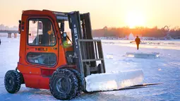 Pekerja menggunakan alat berat mengumpulkan es dari Sungai Songhua di Harbin, ibu kota Provinsi Heilongjiang, China timur laut (7/12/2020). Bongkahan es yang dikumpulkan dari Sungai Songhua yang membeku itu akan digunakan sebagai dekorasi kota tersebut. (Xinhua/Wang Song)