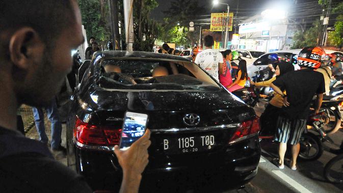 Sebuah mobil sedan Toyota Camry warna hitam berplat nomor B 1185 TOD rusak akibat diamuk warga di kawasan Saharjo, Jakarta, Kamis (18/4). Warga mengamuk karena diduga pengemudi menabrak belasan pengendara sepeda motor dan mobil dari Jalan Tendean hingga Jalan Saharjo. (Liputan6.com/Herman Zakharia)