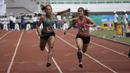 Atlet Jawa Timur, Tri Setyo Utami (kiri), meraih emas lari 100m putri PON XIX Jawa Barat 2016 setelah mengalahkan atlet Sumatra Barat, Lusiana Satriani (kanan) dalam final di Stadion Pakansari, Bogor, Kamis (22/9/2016). (Bola.com/Arief Bagus)