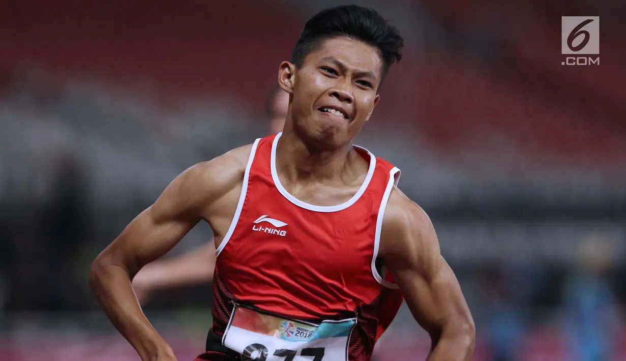 Atlet para-atletik Indonesia, Sapto Yogo Purnomo usai laga lari nomor 100 meter T37 pria yang  digelar di Stadion GBK, Jakarta, Selasa (9/10). Ini menjadi medali emas kedua Sapto di Asian Para Games 2018. (Liputan6.com/Helmi Fithriansyah)