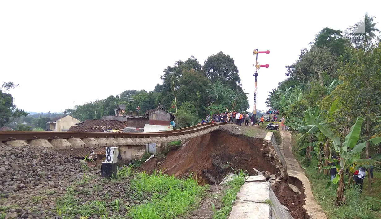 Jalur kereta api tujuan Bogor-Sukabumi longsor terlihat di Kampung Maseng RT02/08, Desa Warung Menteng, Kecamatan Cijeruk, Selasa (5/2). Material longsor menimpa tiga rumah yang ada di bawahnya. (Liputan6.com/Achmad Sudarno)