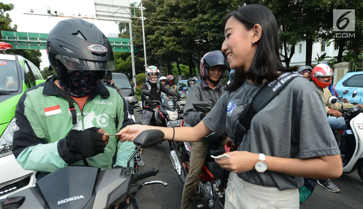 Sejumlah mahasiswi membagikan stiker kepada pengendara saat mengampanyekan keselamatan berlalu lintas di Jakarta, Rabu (20/3). Aksi ini mengajak pengendara untuk tertib berlalu lintas dengan #SelamatDijalan. (merdeka.com/Imam Buhori)