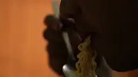 Seorang pria memakan mi kuning basah yang diduga mengandung formalin. (Liputan6.com/M. Khadafi)