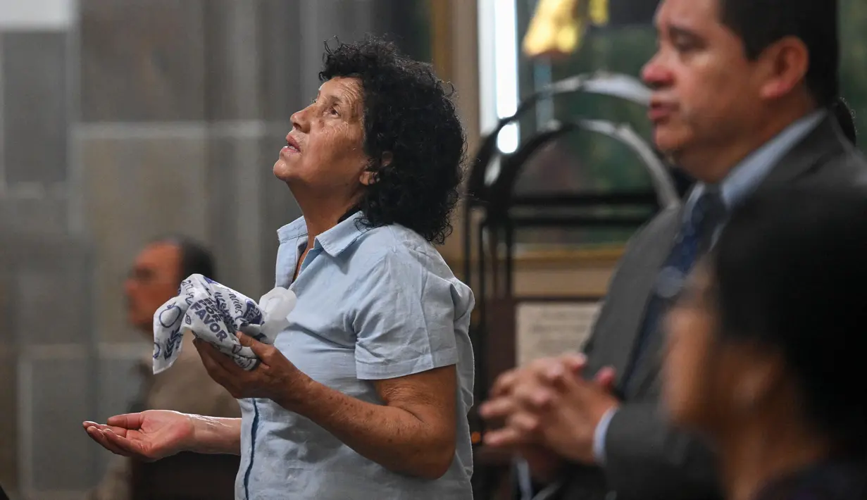 Seorang wanita berdoa dalam sebuah misa untuk kesehatan Paus Fransiskus di Katedral Metropolitan di Guatemala City pada 23 Februari 2025. (JOHAN ORDONEZ/AFP)