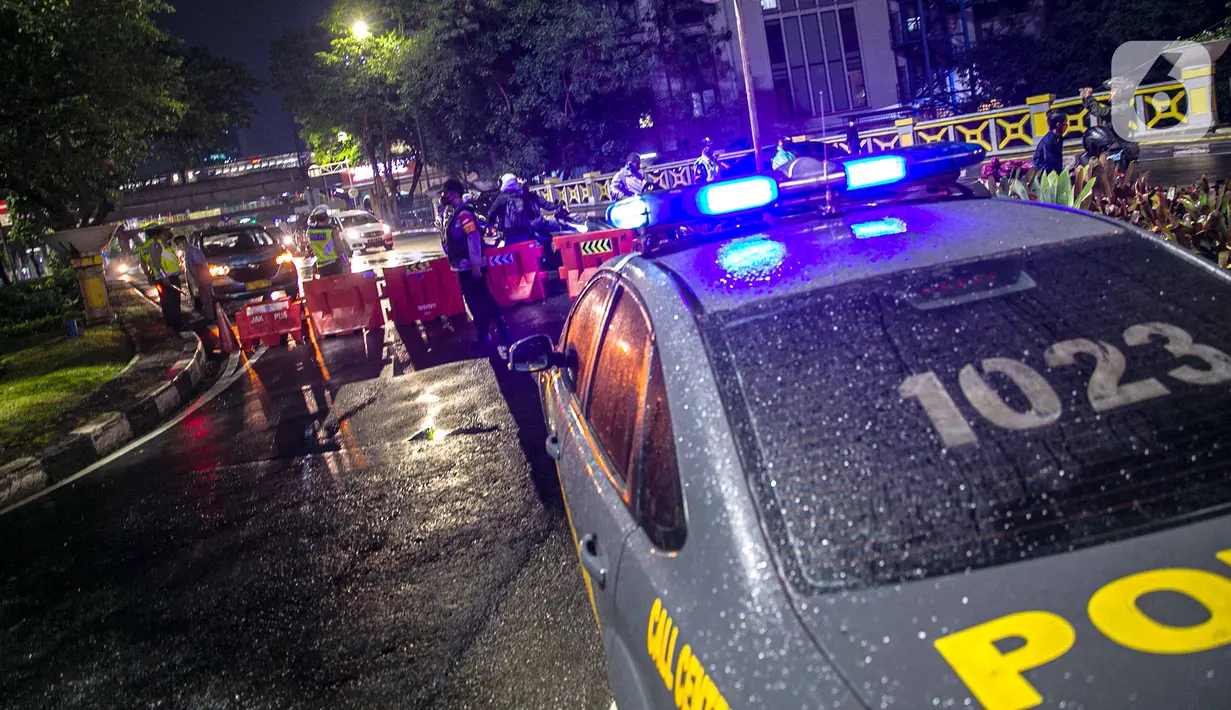 Polisi berjaga saat penyekatan jalan di kawasan Pasar Baru, Jakarta, Kamis (31/12/2020). Polda Metro Jaya menutup sejumlah ruas jalan selama Car Free Night dan Crowd Free Night pada malam Tahun Baru 2021 untuk mencegah penyebaran COVID-19. (Liputan6.com/Faizal Fanani)