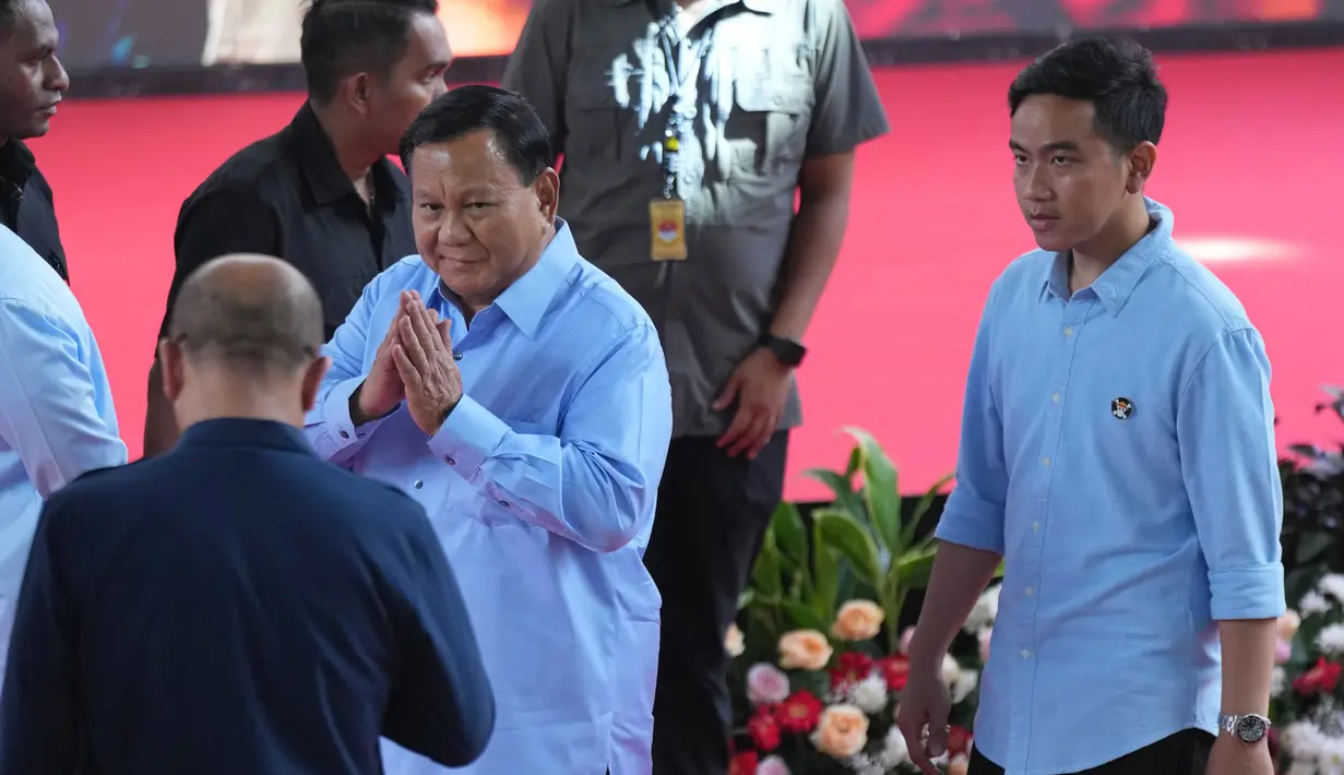 Calon presiden dengan nomor urut 2, Prabowo Subianto (kiri) menyapa Ketua Komisi Pemilihan Umum Hasyim Asyari saat berjalan bersama pasangannya Gibran Rakabuming Raka, (kanan) setibanya untuk menghadiri "Deklarasi Kampanye Pemilu Damai" di Gedung Komisi Pemilihan Umum (KPU), Jakarta, Senin, 27 November 2023. (AP Photo/Tatan Syuflana)