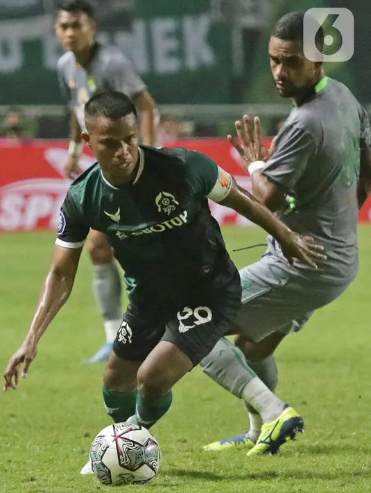 Kapten tim Persikabo 1973, Manahati Lestusen mengecoh pemain Persebaya Surabaya pada lanjutan pekan pertama BRI Liga 1 Indonesia 2022-2023 di Stadion Pakansari, Kabupaten Bogor, Senin (25/7/2022). Persikabo 1973 unggul atas Persebaya Surabaya lewat gol dari titik penalti yang dicetak Gustavo Tocantins. (Liputan6.com/Helmi Fithriansyah)