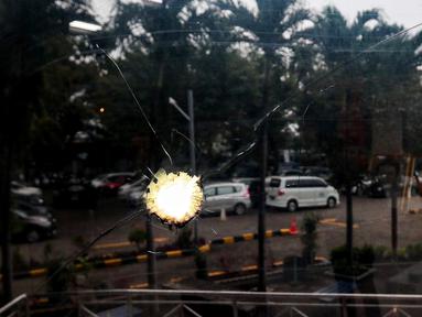 Potret kaca dengan bekas tembakan peluru yang masih tertanam di lokasi aslinya menjadi saksi bisu perjuangan para mahasiswa diabadikan di Museum Tragedi 12 Mei 1998 Universitas Trisakti, Jakarta, Jumat (23/5/2025). (Liputan6.com/Herman Zakharia)