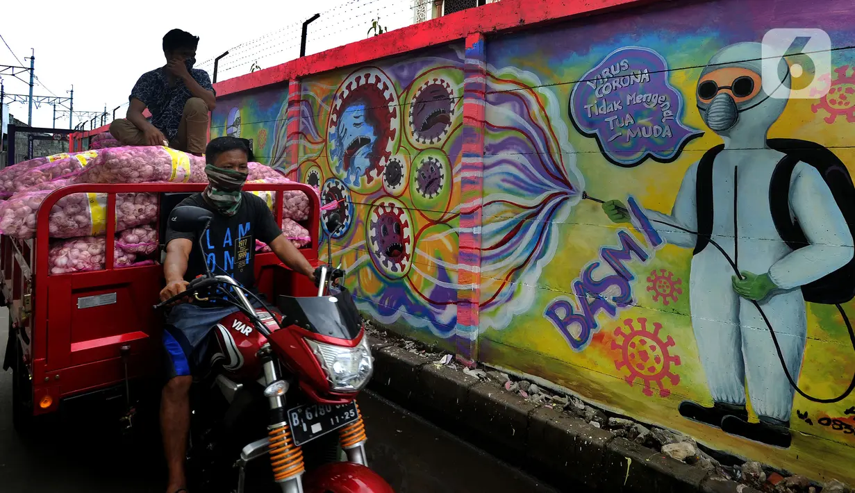 Pengendara sepeda motor melintasi mural bertema COVID-19 di kawasan Tanah Tinggi, Tangerang, Banten, Rabu (20/1/2020). Kegiatan ini dalam rangka mensosialisasikan bahaya penyebaran COVID-19 kepada warga pengguna jalan umum. (merdeka.com/Arie Basuki)