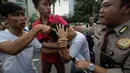 Seorang pria ditangkap massa saat kepergok mencopet saat car free day di kawasan Bundaran HI, Jakarta, Minggu (15/1). Ia sempat dihakimi massa sebelum diserahkan ke polisi. (Liputan6.com/Faizal Fanani)
