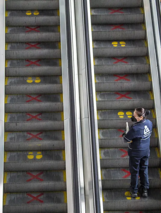 Seorang pekerja menggunakan eskalator di Bandara Internasional El Dorado, Bogota, Kolombia, Senin (31/8/2020). Presiden Kolombia Ivan Duque mengizinkan lebih banyak penerbangan domestik mulai September. (Juan BARRETO/AFP)